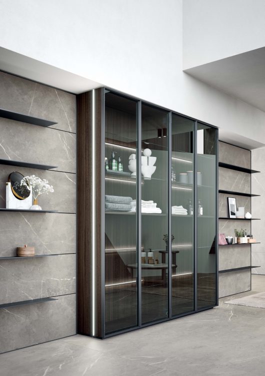 Alu tall units in brushed black aluminium frame with smoked glass doors, with integrated Led lighting behind the shelves 