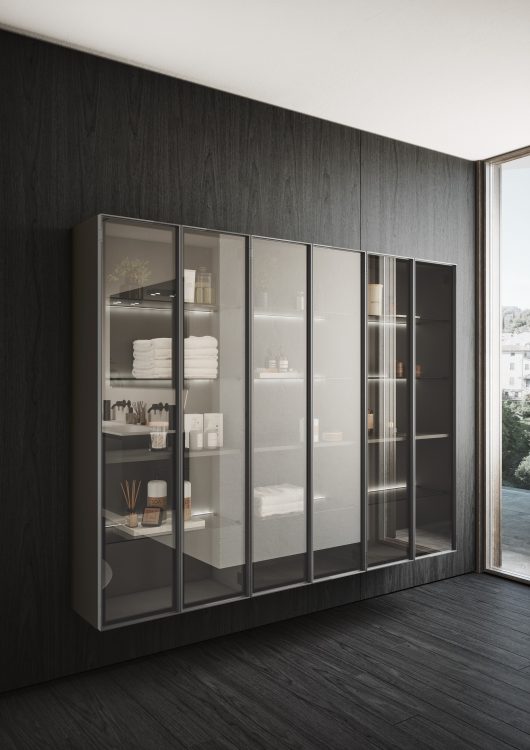 Alu wall-hung tall units with Led lighting behind the shelves. Frame in brushed black aluminium with smoked glass doors 